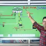 Man pointing to a BLDC motor diagram on a digital smartboard with handwritten circuit details.