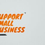 Text “Support Small Business” in bold orange letters on a light background with accent lines.